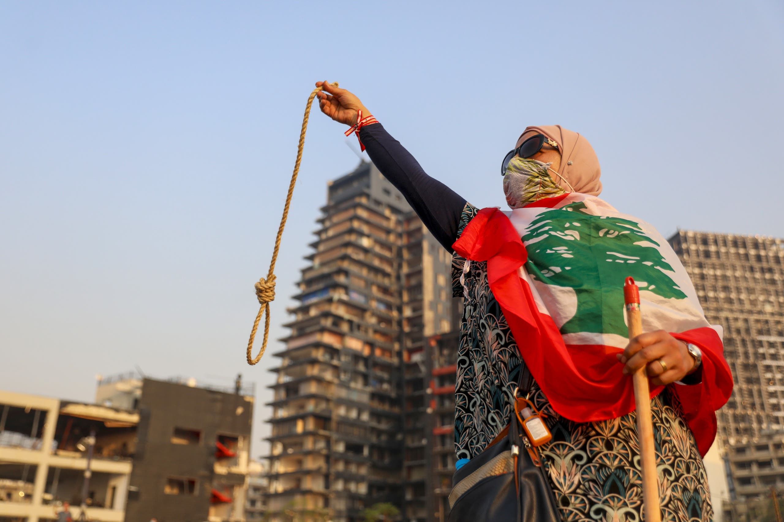 متظاهرة في لبنان تدعو لمحاسبة المتورطين في انفجار مرفأ بيروت حاملة حبل مشنقة (أرشيفية- فرانس برس)