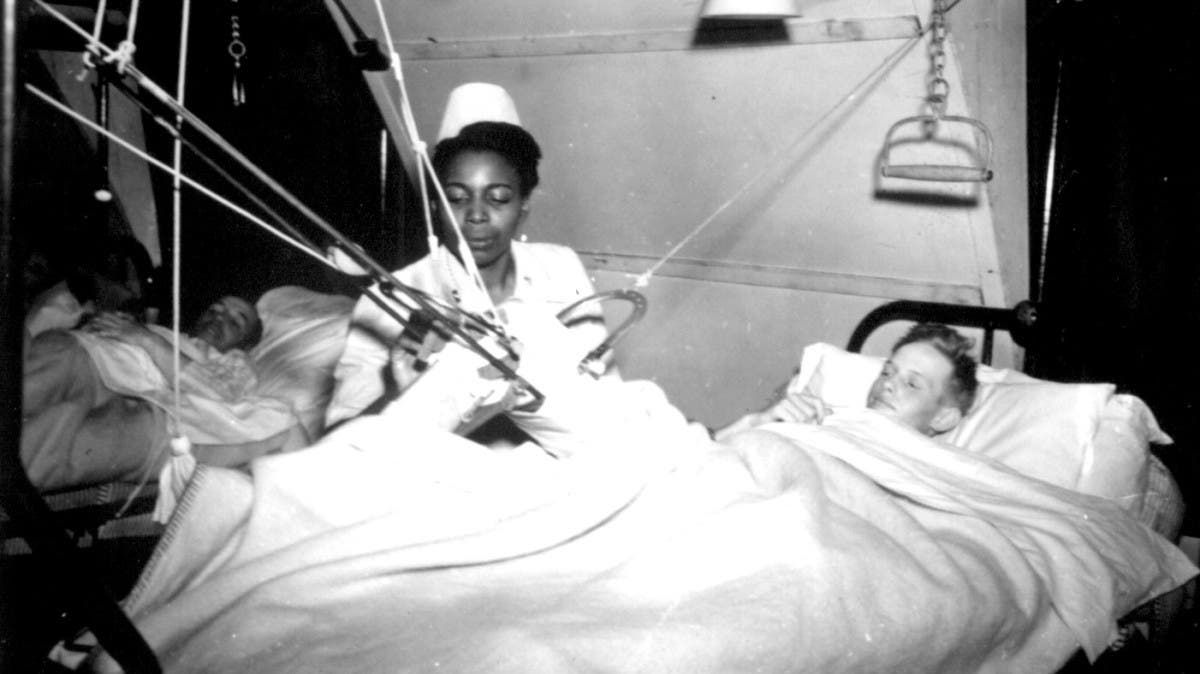 صورة لممرضة أميركية من السود أثناء اعتنائها بأسير ألماني
