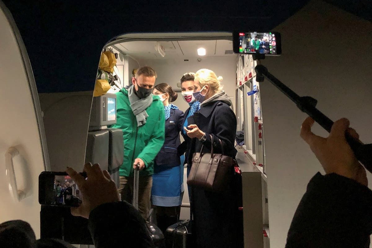مع زوجته أثناء خروجه من الطائرة في موسكو(رويترز)