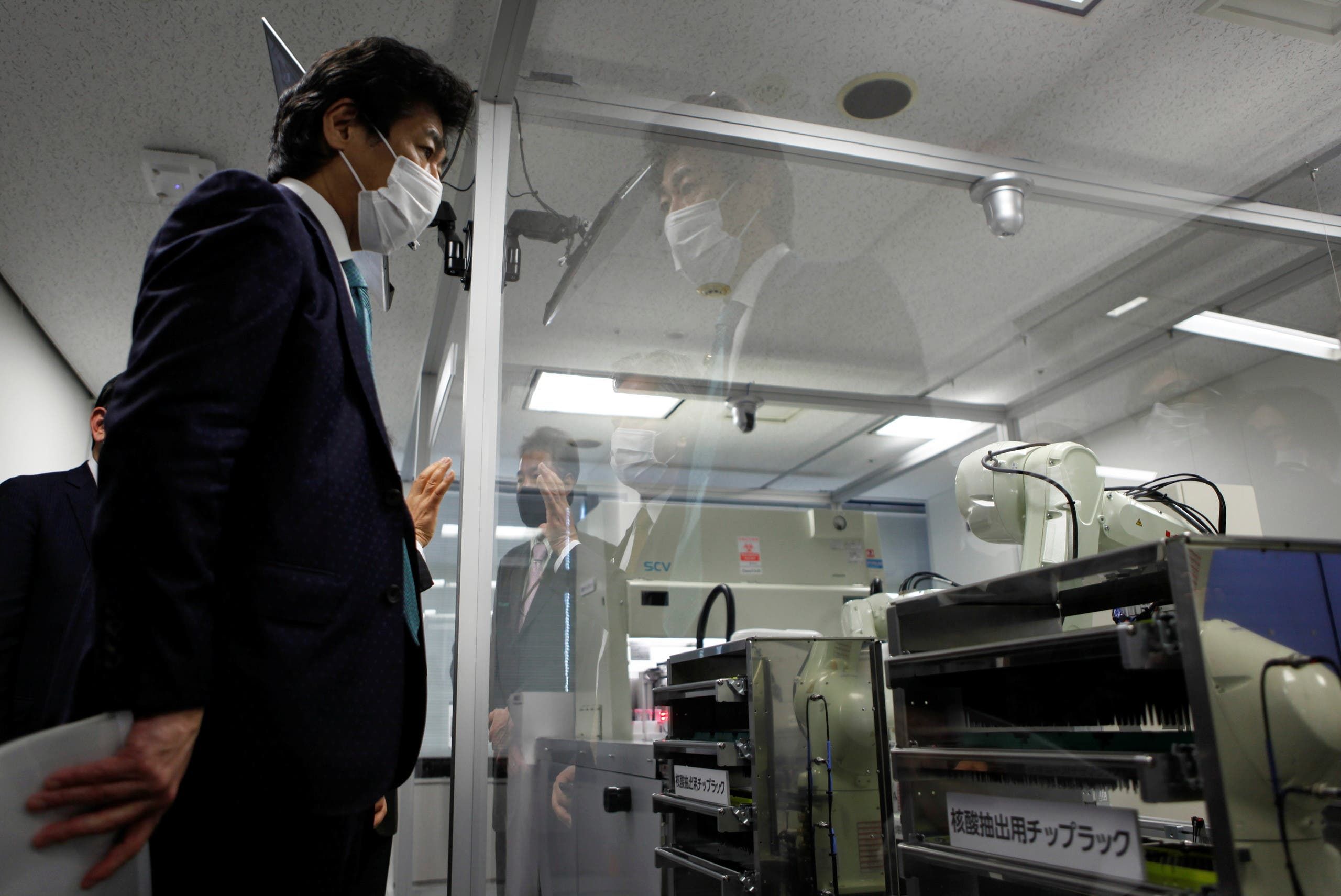 وزير الصحة الياباني نوريهيسا تامورا يعاين الروبوت الجديد