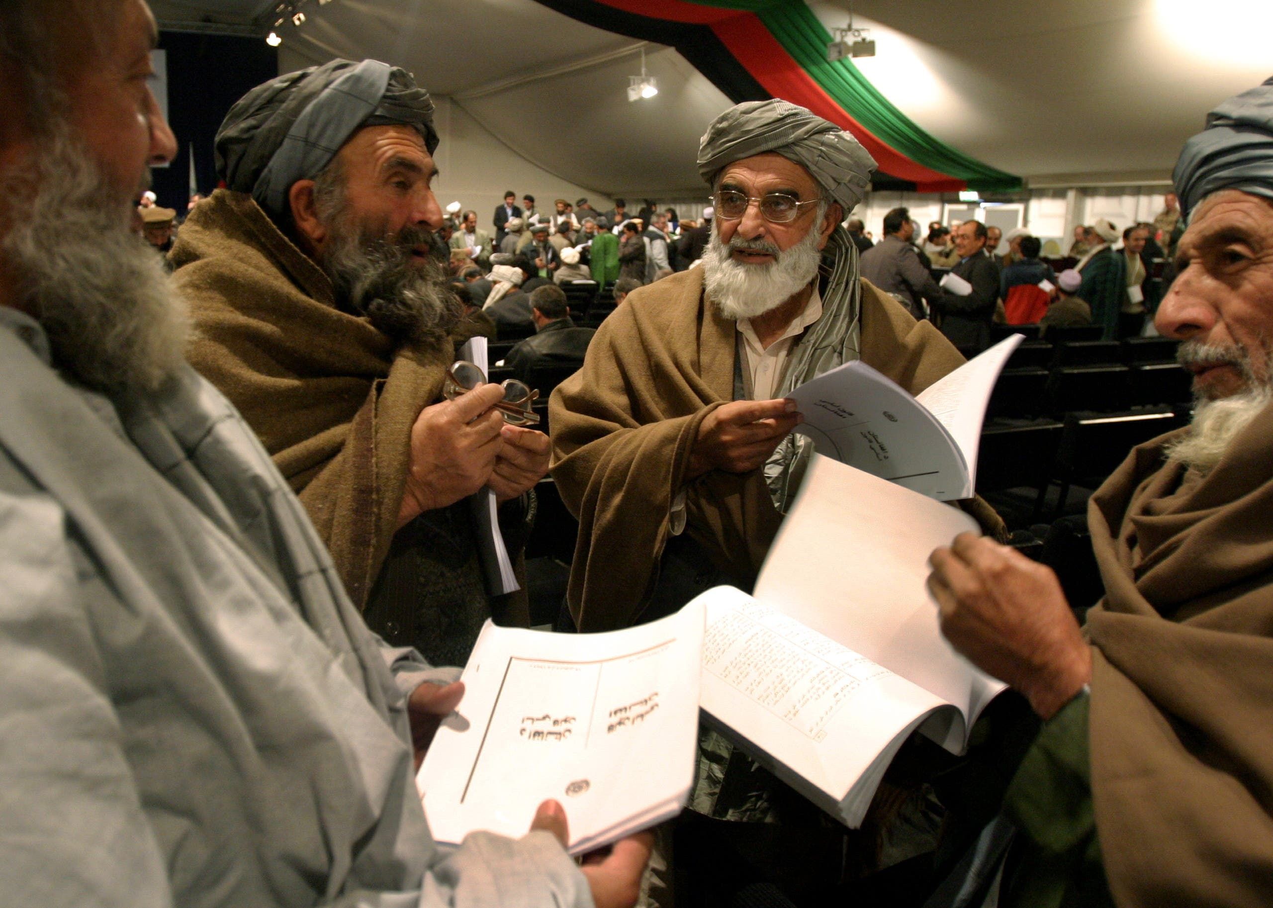 أعضاء في البرلمان الأفغاني يقرؤون الدستور الجديد للبلاد الذي تم تبنيه في 2004